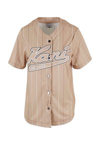 Beige Baseball-Jersey mit kurzen Ärmeln, weißen vertikalen Streifen, Frontknöpfen und "Kani"-Logo mit dem Gründungsjahr auf der Brust bedruckt.