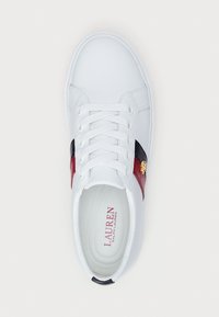 Valged tennisjalanõud sileda nahast pealispinnaga, millel on burgundi ja must riba ning kuldne logoaksent külgedel. Sidumisdisain.