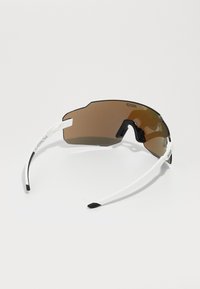 Sportsonnenbrille mit braunen Gläsern, weißem Rahmen und schwarzen Akzenten. Das Design verfügt über eine umschließende Form und belüftete Gläser für Luftzirkulation.