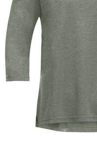 Olijfgroen langesleeve top, zachte textuur, gebogen zoom, zijsplitten en een ontspannen pasvorm met een losse silhouet.