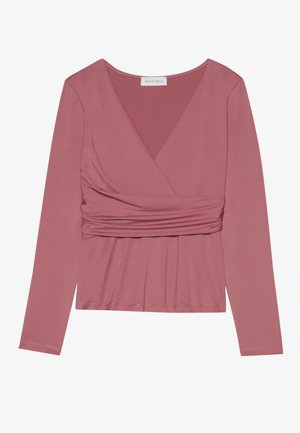 Langermet topp i støvet rosa, med omslagdesign, samlet materiale i midjen og v-hals. Myk tekstur med minimale sømmer.