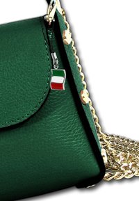 Groene leren handtas met gouden kettingstrap, magnetische klep sluiting en een klein Italiaans vlaghangertje. Gestructureerde vorm en textuur.
