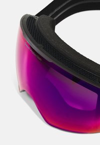 Occhiali protettivi con montatura nera e lenti viola, dotati di un'imbottitura in schiuma testurizzata per il comfort e il marchio "Sweet Protection".