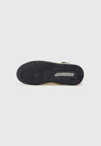 Suela de sneaker negra de goma con patrones texturizados y un prominente logo blanco de "JORDAN". Bordes reforzados y diseños de tracción variados visibles.