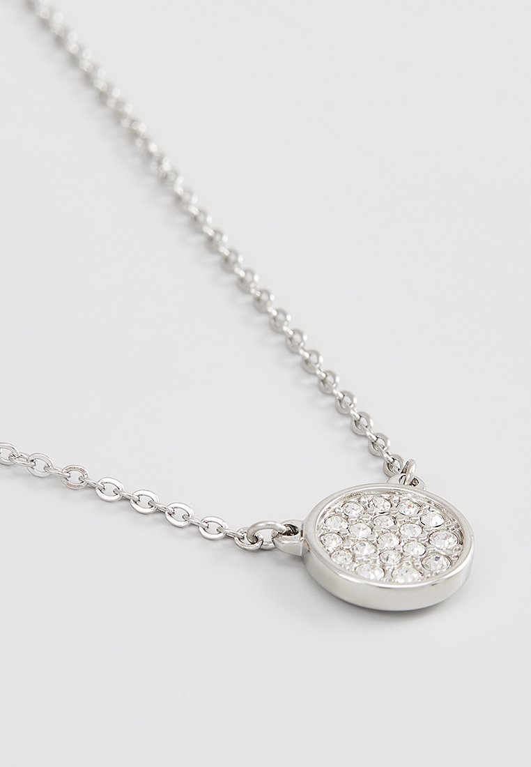 Collana in argento con un pendente rotondo incastonato di piccoli cristalli trasparenti su uno sfondo bianco.