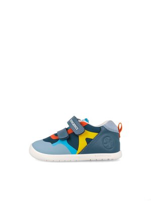 Sneaker da bambino con pannelli blu, gialli, arancioni e turchese, due cinturini in velcro, suola bianca e linguetta arancione sul retro.