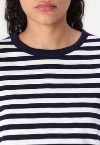 Marinblå och vit randig t-shirt med rund halsringning och mjukt tyg, med växelvis breda ränder för kontrast.