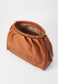 Rjava usnjena torbica z nabranim vrhom, zloženi zlatimi elementi in embosiranim logotipom. Notranjost vsebuje žep na zadrgo in gladko podlogo.