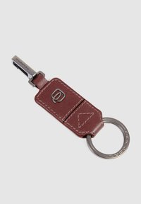 Leather keychain in burgundy with a metal keyring, featuring a logo embossed on the front and visible stitching details.