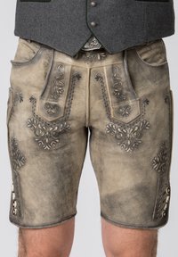 Pantaloni corti in pelle con un ricamo grigio intricato. Presentano tasche e bottoni decorativi. Design affusolato, colore marrone chiaro con una finitura testurizzata.