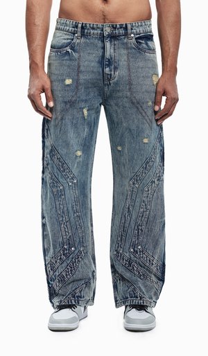 Lichte blauwe wijde denim jeans met versleten plekken, opvallende hoekige naden en een gestructureerde afwerking. Gecombineerd met witte sneakers.