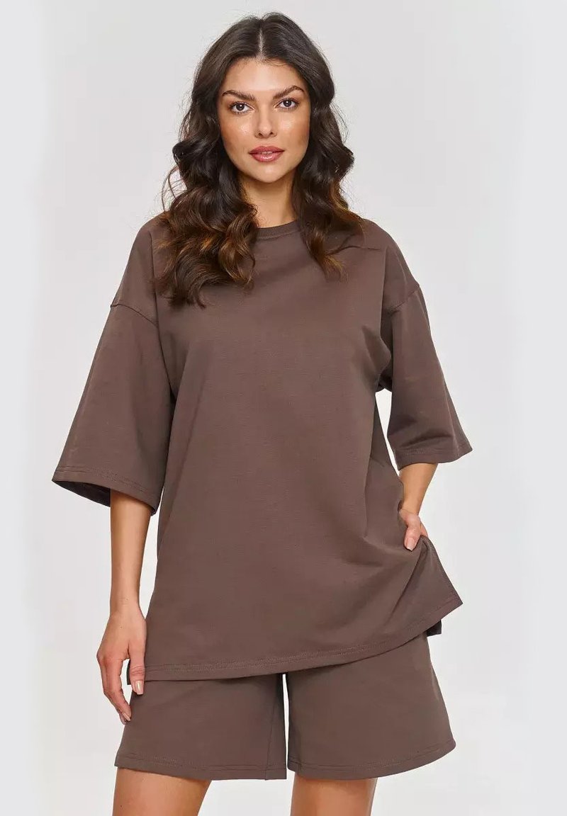 Brązowy, oversize t-shirty z krótkim rękawem, w połączeniu z pasującymi szortami do kolan. Miękka tkanina o luźnym kroju i bez widocznych wzorów.