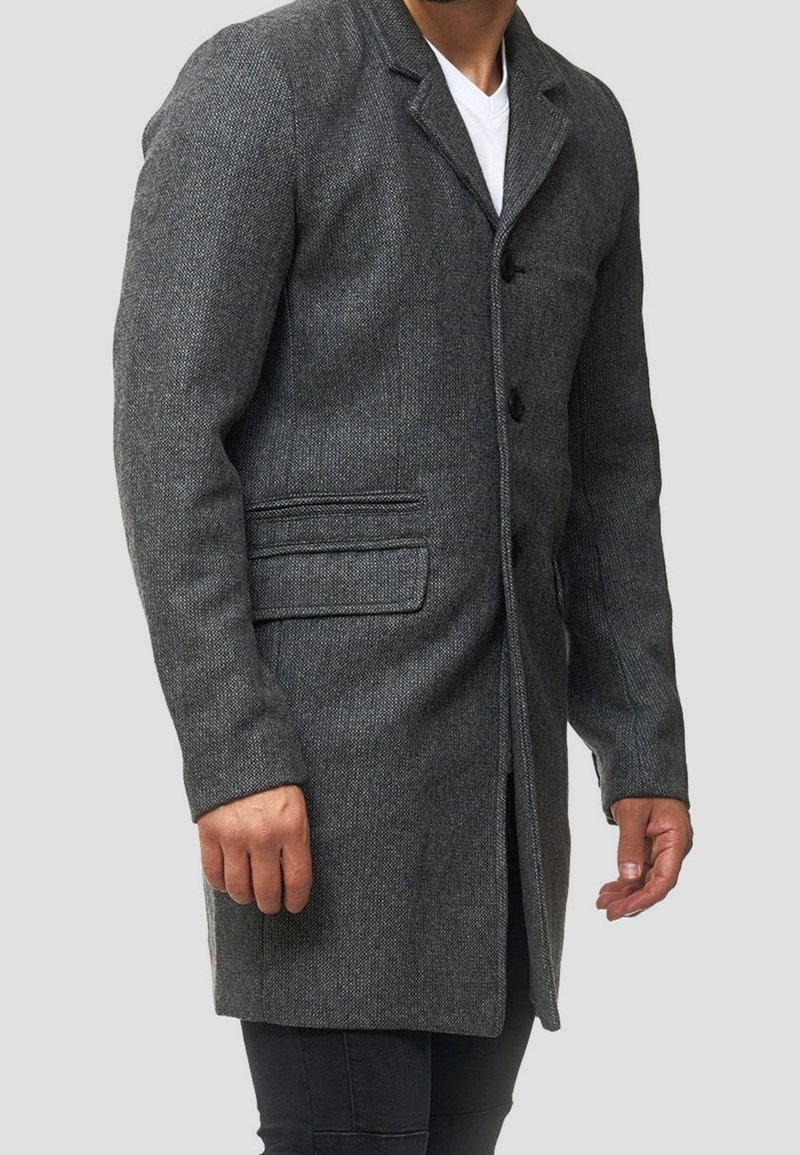 Grå textured frakke med knaplukning foran, hakket krave og sidelommer. Slank pasform med en midtlængde snit.