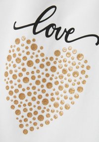 Tela blanca con un texto en cursiva negro que dice "amor" sobre una forma de corazón llena de puntos de purpurina dorada de diferentes tamaños.