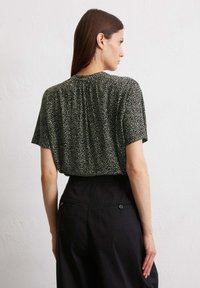 Zwart-wit gestreepte blouse met korte mouwen en een losse pasvorm, met een ronde halslijn en plooidetail aan de achterkant.
