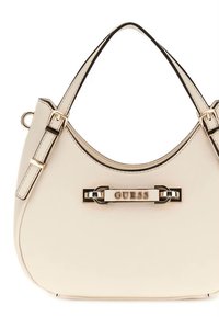 Cremefarbene Handtasche aus Synthetik mit geschwungener Form, goldfarbenen Beschlägen und zentralem Logo-Schild. Verstellbare Träger und kontrastierende schwarze Akzente.