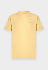 Ανοιχτό κίτρινο κοντομάνικο T-shirt με μικρό μπλε και κόκκινο λογότυπο "Rip Curl" στην αριστερή πλευρά του στήθους, απλό φόντο.