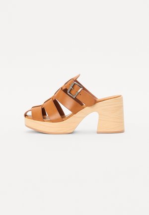Bruine leren sandalen met meerdere banden en een gespdetail. Voorzien van een licht houten plateau en een chunky hak. Open tenen ontwerp.