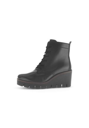 Bottine en cuir noir à bout rond, semelle en wedge, lacets sur le devant et couture détaillée le long des bords. Finition texturée.