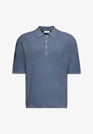 Niebieska dzianinowa koszulka polo z krótkim rękawem, z teksturowanym wzorem, czterema białymi guzikami i klasycznym kołnierzem, oznaczona marką Calvin Klein Jeans.