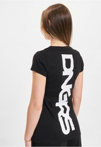 Black cotton t-shirt with short sleeves, featuring large white lettering "DNGRS" printed vertically on the back. Simple and minimalist design.