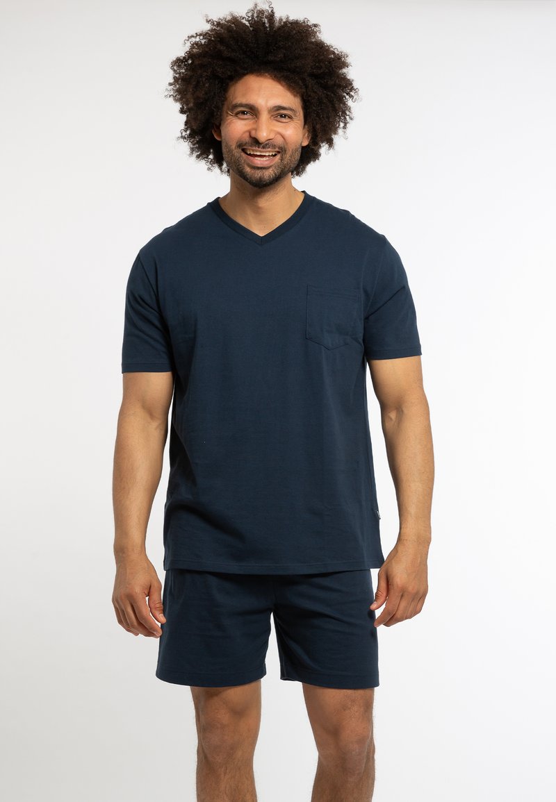 Navyblaues V-Ausschnitt-T-Shirt mit kurzen Ärmeln und einer Tasche, kombiniert mit passenden Shorts. Beide Teile haben eine glatte, weiche Textur.