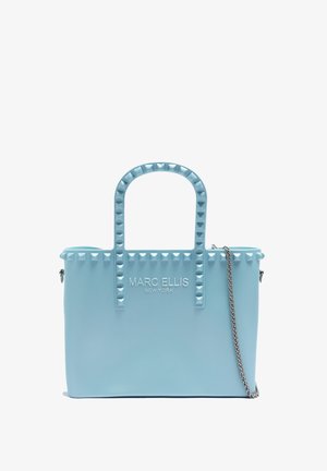 Lichtblauwe tote bag van glad materiaal, met piramide studs op de handvatten, zilveren kettingriem en een gegraveerd logo aan de voorkant.