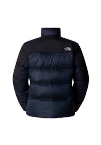Marinblå pufferjacka med svart övre del, med hög krage och horisontell quiltad mönstring. The North Face-logotypen visas på baksidan.