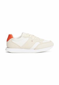 Sneakers beige e bianchi con tomaia in suede e pelle, dotati di un distintivo accentuato arancione sul tallone e suola in gomma testurizzata.