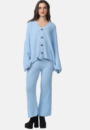 Set da lounge a coste blu, composto da un maglione oversized con bottoni, scollo a V e maniche ampie, abbinato a pantaloni larghi coordinati.