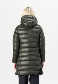 Abrigo acolchado color verde oliva con capucha, con secciones acolchadas, textura brillante y diseño de longitud media, adecuado para clima frío.