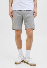 Gray, knee-length shorts with a relaxed fit, made of a textured fabric. Features front pockets and a subtle stitch detail. Worn with white sneakers.