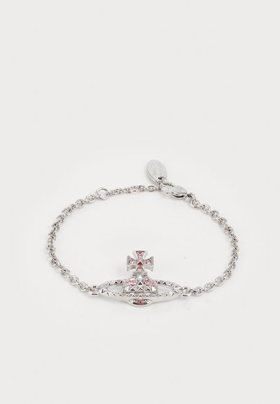 Bracelet en chaîne argentée ornée d'un charm en forme de couronne texturé avec des pierres précieuses roses et un accent en croix, affichant un détail intriqué.