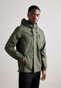 Olive green waterproof jacket featuring a hood, elastic cuffs, and zippered chest pocket. Smooth texture with minimalistic design.