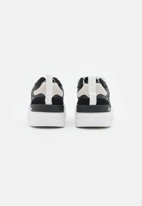 Baskets en suède noir et mesh avec des accents blancs, col rembourré, languette de traction et semelle épaisse en caoutchouc blanc. Conçu pour le confort et le soutien.