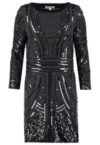 Robe noire à manches longues avec des motifs géométriques en sequins et perles couvrant tout le vêtement, avec un col rond.