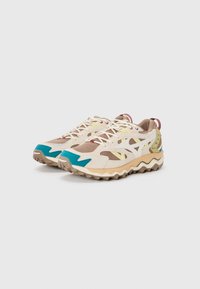 Beżowe siatkowe sneakersy z akcentami w kolorze turkusowym i żółtym, zygzakowata podeszwa oraz wielomateriałowy design z zamszu i tekstyliów. Sznurówki z czerwonymi detalami.