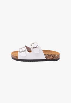 Sandalo bianco con punta aperta, due fibbie regolabili in argento, soletta in sughero e suola in gomma nera, mostrato di lato su sfondo bianco.