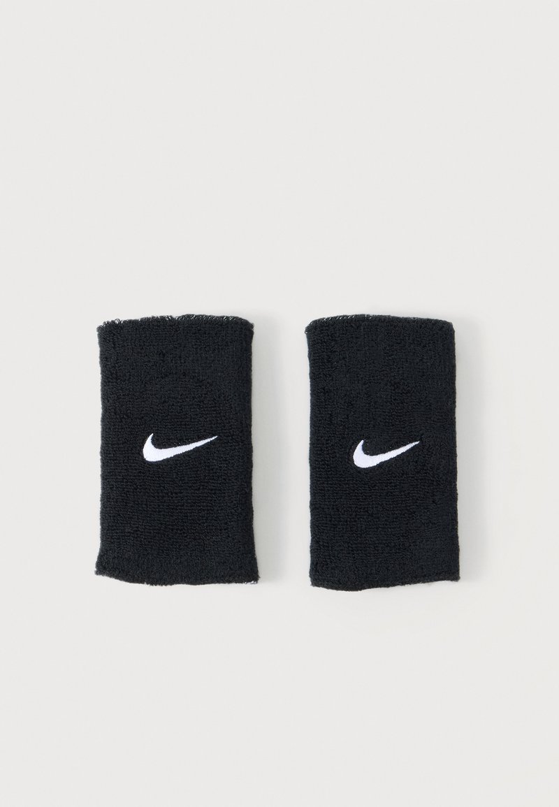 Pár černých tenisových potírek Nike z froté látky s bílými logy Swoosh uprostřed každého pásku na bílém pozadí.