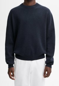 Marineblaues Rundhals-Pullover aus weichem Strickstoff. Mit gerippten Bündchen und Saum, einem leicht lockeren Schnitt und subtiler Textur.