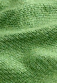 Textúrovaná zelená látka s jemným tkaným vzhľadom, obsahujúca rôzne odtiene zelenej a vlnenú textúru.