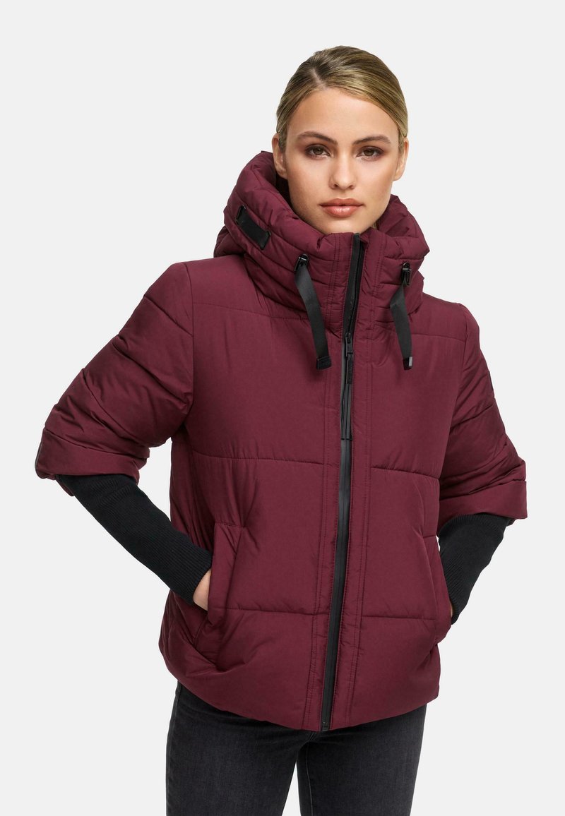 Burgundy padded jacket with a high collar, zip closure, and black accents. Features a quilted design and side pockets.