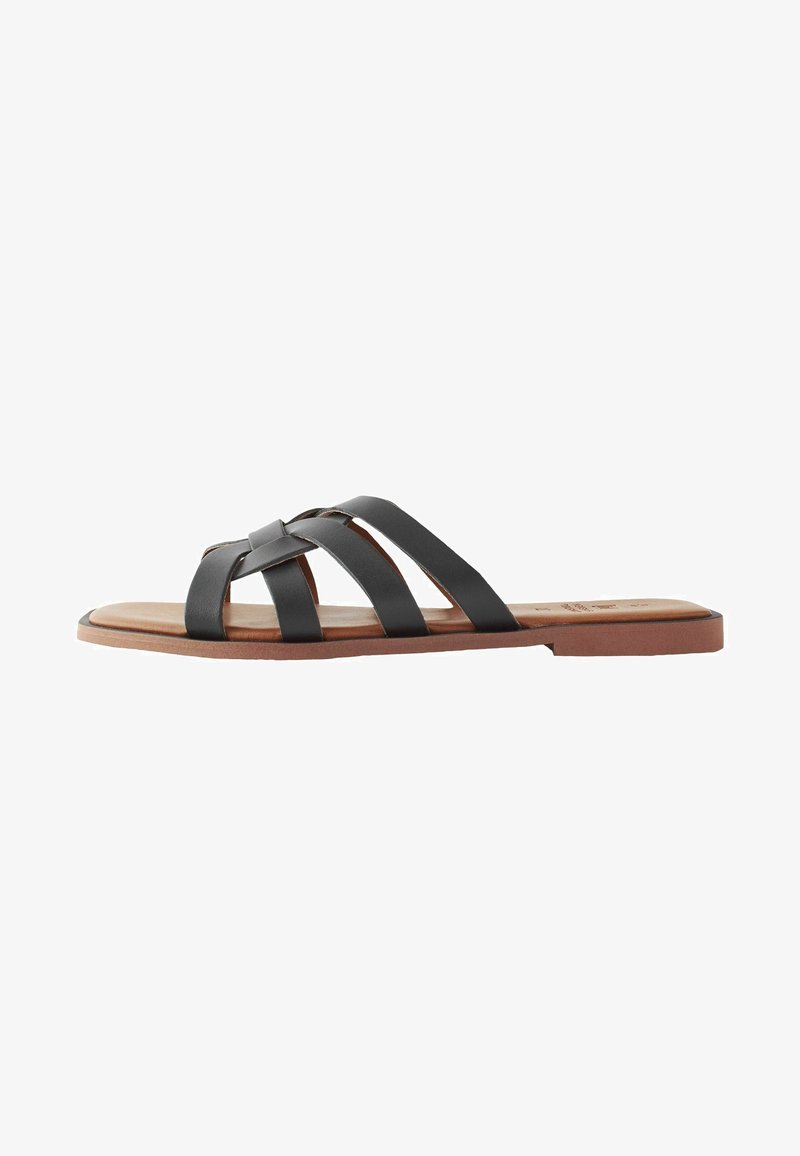 Fekete bőr slip-on szandál, három keresztben átkötött pánttal, lapos barna talppal és sima felülettel. Kényelmes hétköznapi viselethez.