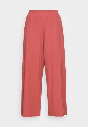 Wide-leg pants in a coral color with a ribbed texture and an elastic waistband, featuring long, flowing legs and no visible hardware.