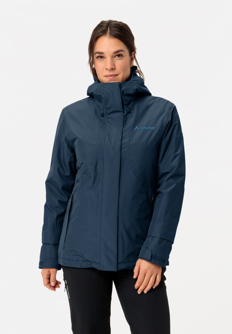 Navy wasserdichte Jacke mit hohem Kragen, verstellbarer Kapuze und seitlichen Reißverschluss-Taschen. Merkmale sind eine glatte Textur und ein Logo-Akzent.