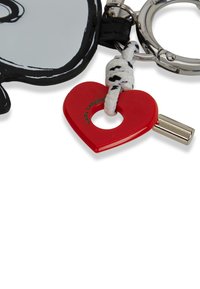 Portachiavi con un design in bianco e nero, charm a forma di cuore rosso, parti in argento e un attacco in corda intrecciata nera con texture.