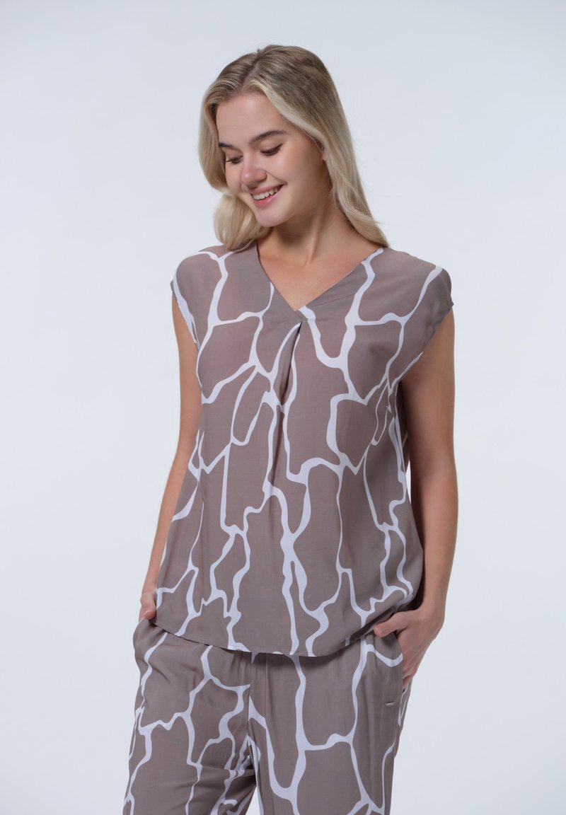 Mouwloze top in beige met een abstract wit patroon, voorzien van een V-hals en geplooide details aan de voorkant. Zachte, lichtgewicht stof.