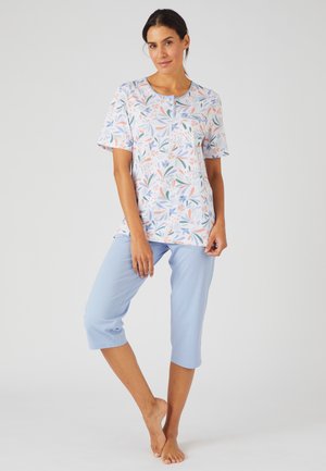 Bloemige top met korte mouwen in pasteltinten, met een ronde halslijn en knoopdetails, gecombineerd met lichtblauwe cropped broek van zachte stof.