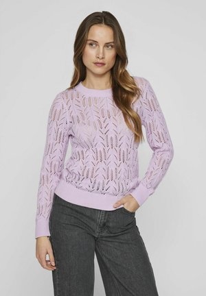 Lila gebreide trui met een kantpatroon, ronde halslijn en geribde manchetten en zoom. Gepaarde met donkergrijze jeans.