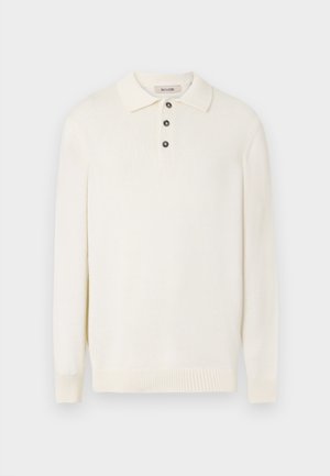 Pull en maille à manches longues de couleur crème, fabriqué en tissu doux. Il présente un col classique et trois boutons sombres le long de la patte de boutonnage.